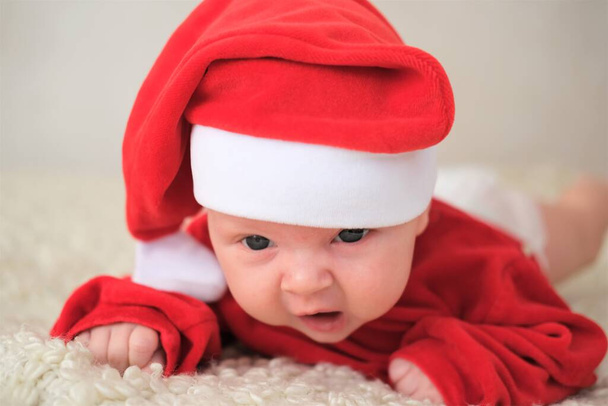 baby in santa costume on white background.Crawling baby in Santa Claus costume - Zdjęcie, obraz