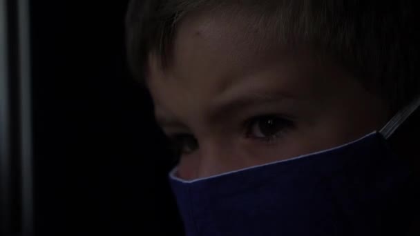 小さな乗客は電車の窓を見て顔マスクを着ていた。少年は太陽を見る。列車で保護マスク旅行で6歳の少年。学校に戻る。休暇から戻る。COVID-19, coronavirus - 映像、動画