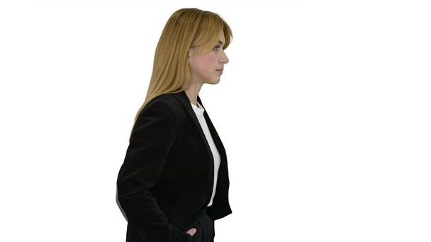Walking businesswoman with hands in pockets on white background. - Photo, Image