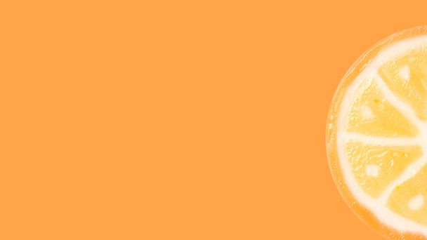 Slice of sugar orange candy on an orange background with copy space. Concept of sugar and candies. - Fotó, kép