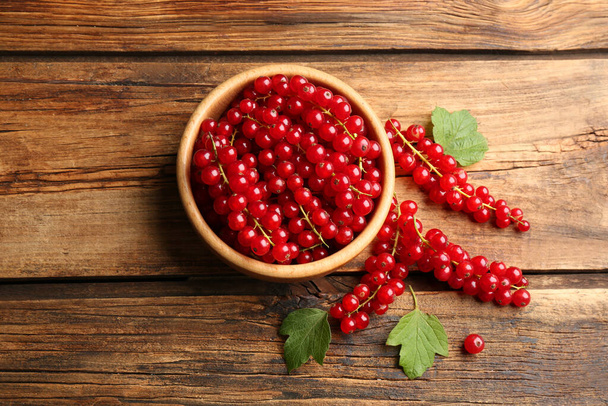 Delicious ripe red currants on wooden table, flat lay - Valokuva, kuva