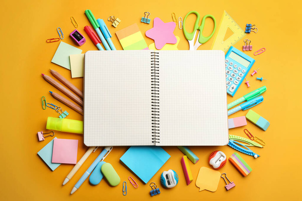 Blank notebook and school stationery on orange background, flat lay with space for text. Back to school - Foto, Bild