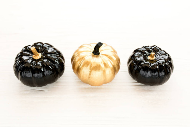 Stylish Halloween decorations. Decorative pumpkin black and gold Halloween isolated on white background. Flat lay, top view. - Zdjęcie, obraz