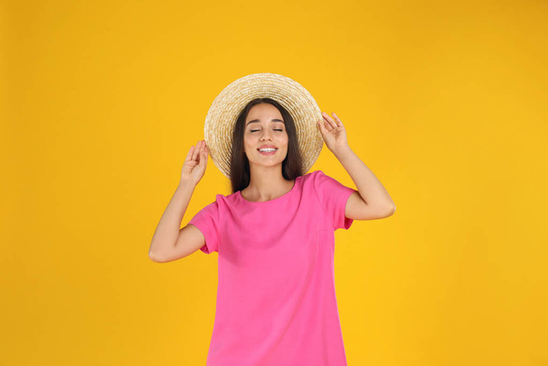 Young woman wearing stylish pink dress on yellow background - Foto, afbeelding