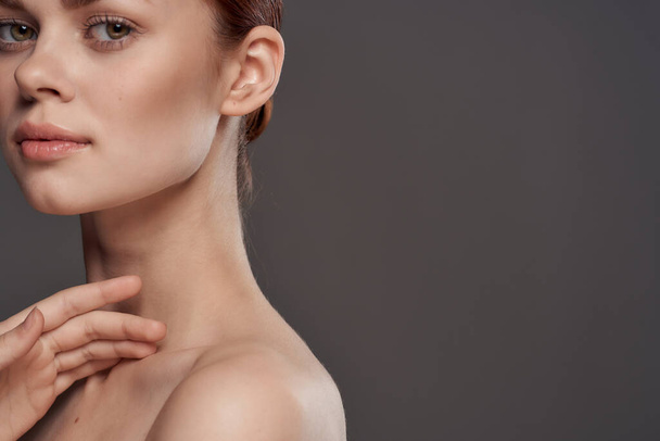 Beautiful woman naked shoulders cosmetics clean skin charm gray background studio - Fotó, kép