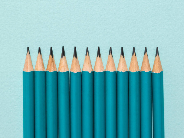 Дванадцять графітових олівців на світло-блакитному фоні
. - Фото, зображення