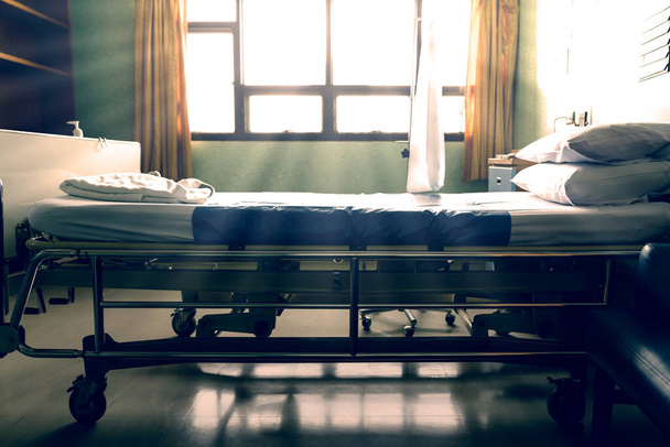 Empty  hospital bed with sunlight from the window,vintage tone - Foto, imagen