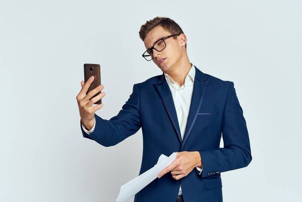 Homme d'affaires en costume parlant au téléphone avec des lunettes avec des documents officiels de la technologie - Photo, image