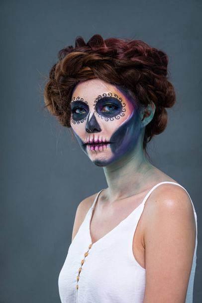 Closeup portrait of a woman with a sugar skull makeup. Halloween concept - Photo, image
