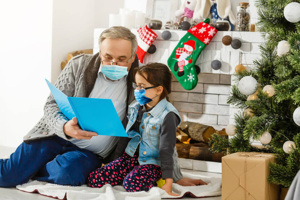 A család védőmaszkot visel, karanténban. Normális élet koronavírussal. Életmód COVID-19. Karantén vírus elleni védelem karácsonykor - Fotó, kép