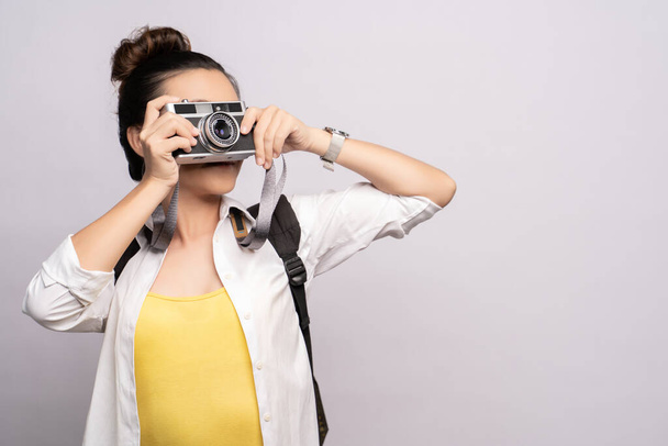 Glückliche Frau macht ein Foto mit der Kamera isoliert über dem Hintergrund - Foto, Bild