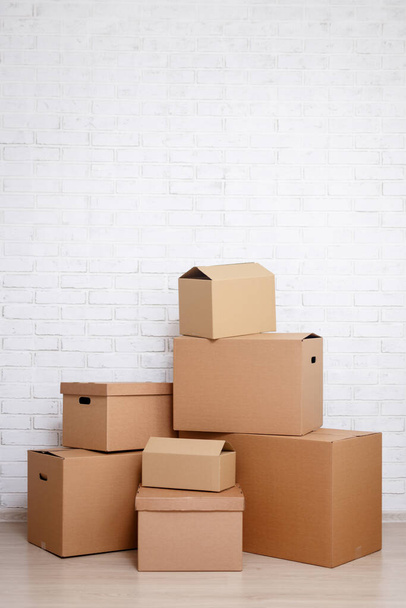 картонные коробки и пространство для копирования на фоне белой кирпичной стены - Фото, изображение