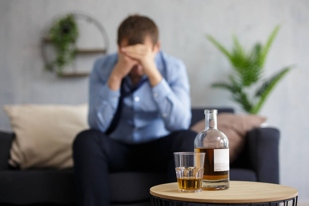 depressiver Geschäftsmann trinkt Alkohol zu Hause oder im Büro - Foto, Bild