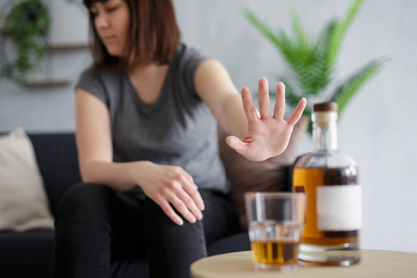 Alkoholismus-Konzept - junge Frau verweigert Glas Whiskey mit Palmgeste - Foto, Bild