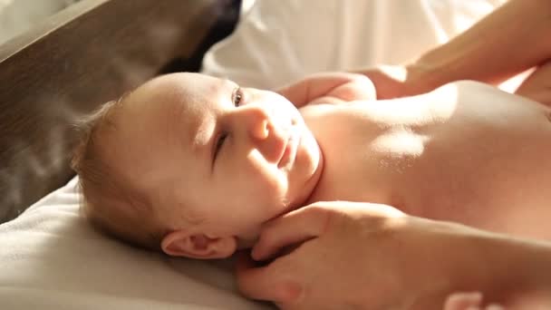 glimlachende kleine baby wordt geklopt door liefhebbende ouders - Video