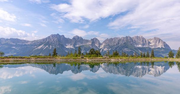 An idyllic landscape with the Wilder Kaiser in the back, reflection in a lake, Going, Austria. - Photo, Image