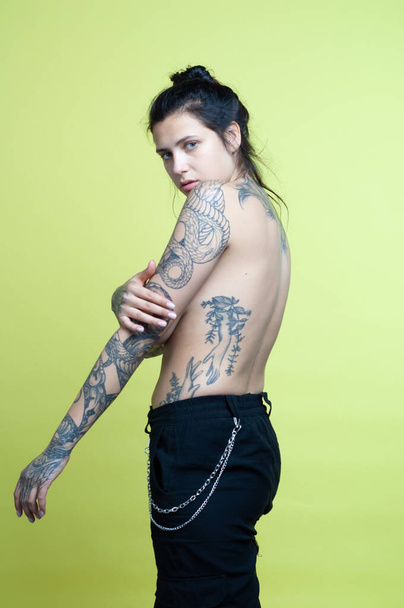 young beautiful woman with tattoo posing nude in studio - Valokuva, kuva