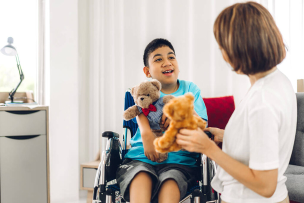 Portrait of asian physiotherapist carer helping and playing with special disabled child health problem by doing exercises sitting in wheelchair in rehabilitation clinic.disability care concept - Foto, afbeelding