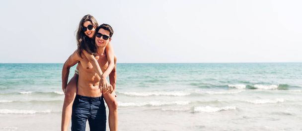 Vacation romantic lovers young happy couple hug and standing on sand at sea having fun and relaxing together with copy space banner for adding text on tropical beach.Summer vacations - Фото, зображення