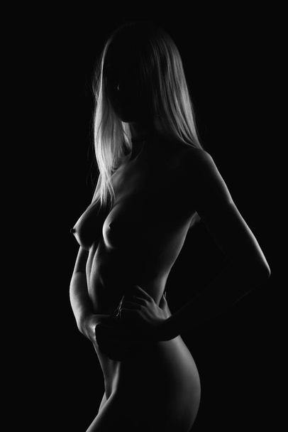 Art nude, perfect naked body, sexy young woman on dark background, black and white photography, studio shot - Fotografie, Obrázek