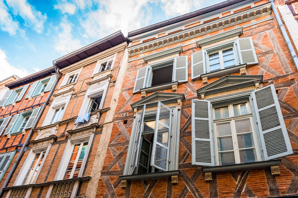 Fachada de un edificio rue Saint-Rome en Toulouse con sus típicos ladrillos rosados, en Haute-Garonne en Occitanie, Francia - Foto, imagen