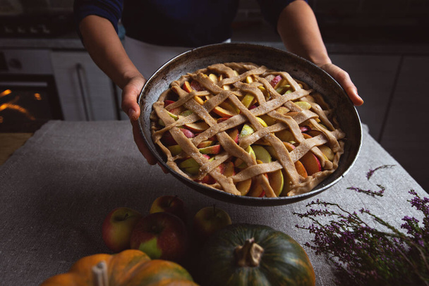 Előkészítés, hálaadás napi ünneplés. A szakács egy teljesen kifejlett, sütésre kész pitét mutat. Hagyományos almás pite készítése. - Fotó, kép