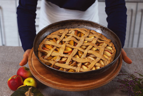 Подготовка, День благодарения. Повар показывает печеный пирог на деревянной доске. Делать традиционный яблочный пирог. - Фото, изображение
