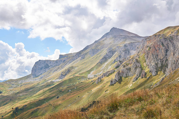 красивий гірський пейзаж зі скелястим хребтом в атмосферному тумані на відстані і осіннім альпійським лугом на передньому плані
 - Фото, зображення