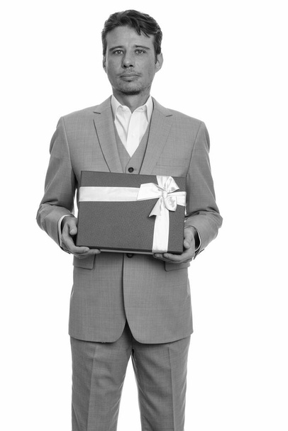 Студійний знімок гарного бізнесмена з бородою в костюмі ізольовані на білому тлі в чорно-білому
 - Фото, зображення