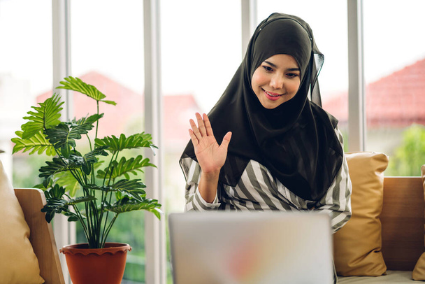 Mladá usměvavá krásná muslimka relaxaci pomocí notebooku pracovní a video konference setkání doma. Práce z domova koncept - Fotografie, Obrázek