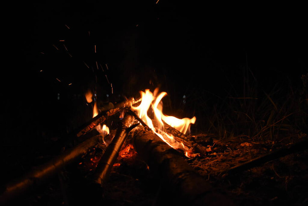 長い炎と火花で夜のキャンプファイヤー - 写真・画像