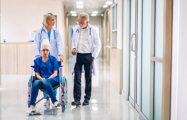 Professional medical doctor team with stethoscope in uniform discussing with patient woman with cancer cover head with headscarf of chemotherapy cancer in hospital.health care concept - Foto, imagen