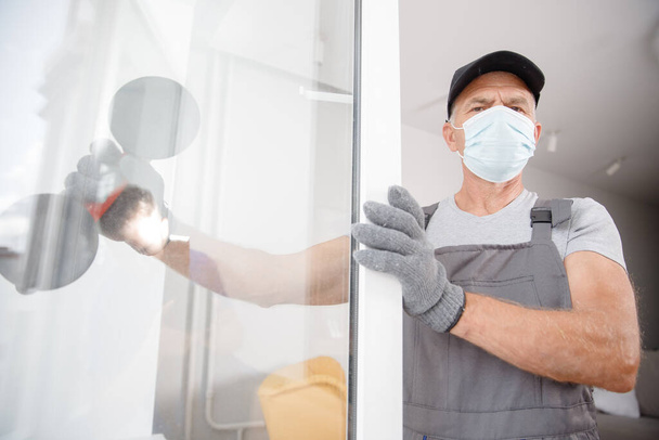 Installs plastic upvc windows and doors worker in medical mask - Foto, Imagem