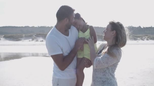 Gioioso giovani genitori holding little daughter in arms - Filmati, video