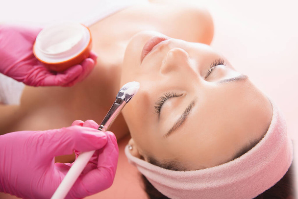 Médecin utiliser brosse appliquer la crème pour les soins de la peau et les cosmétiques concept. Maquillage naturel visage femme - Photo, image