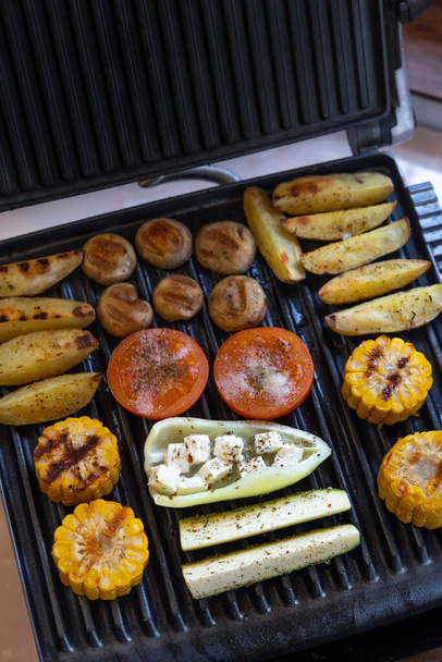 Electric grill with spicy potatoes, mushrooms and vegetables - Foto, Bild