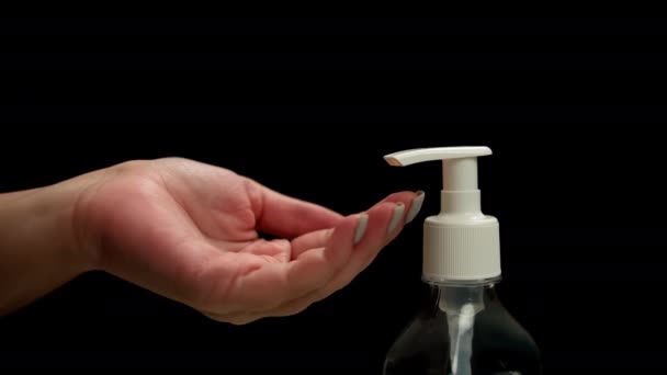 Ženské ruce stiskněte antiseptický dávkovač a stiskněte gel zblízka, tmavé pozadí - Záběry, video