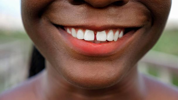 Afroamerikanerin mit Maiskörnern lächelt auf Holzbrücke - Foto, Bild