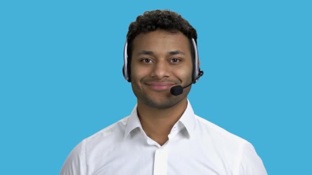 Smiling call center operator on blue background. - Footage, Video