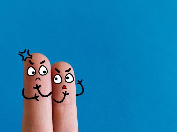 Due dita sono decorate come due persone. Stanno parlando tra loro con rabbia.. - Foto, immagini