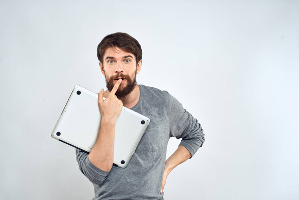 Hombre con portátil en las manos tecnología internet confianza en sí mismo luz de fondo - Foto, imagen