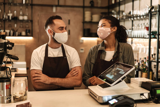Coffee shop owners with face masks, lockdown, quarantine, coronavirus, back to normal concept - Фото, зображення