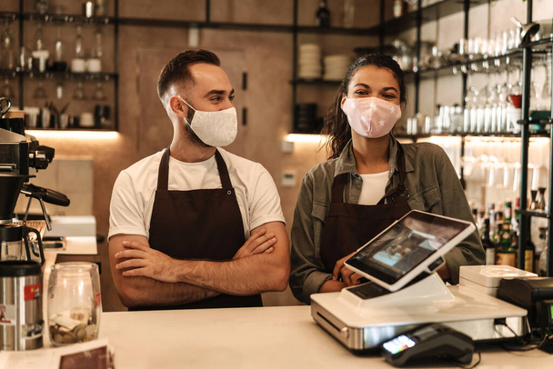 Coffee shop owners with face masks, lockdown, quarantine, coronavirus, back to normal concept - 写真・画像