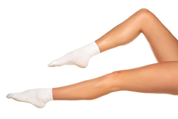 Patas femeninas en calcetines cortos blancos sobre fondo blanco - Foto, imagen