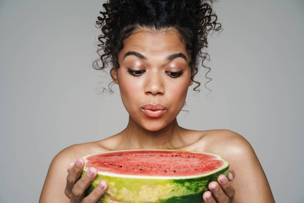 Image of shirtless african american woman posing with watermelon isolated over grey wall - Foto, Imagem