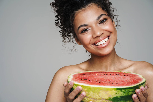 Image of shirtless african american woman smiling while posing with watermelon isolated over grey wall - Fotografie, Obrázek
