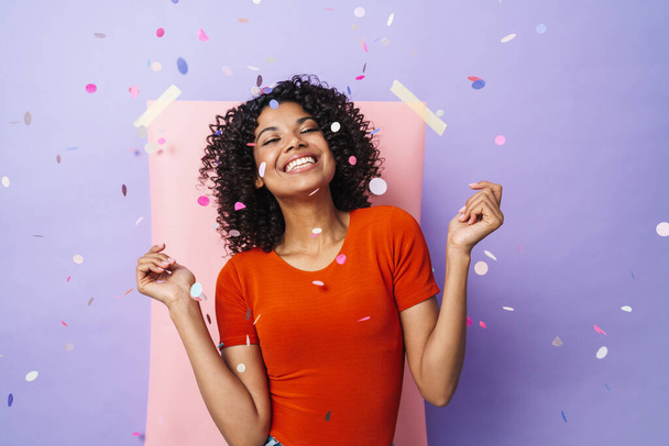Image of funny african american woman smiling and dancing at camera isolated over multicolored background - Foto, immagini