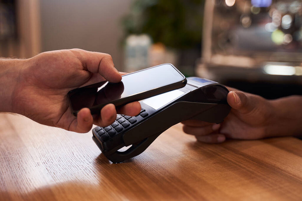 Client paying with contactless smartphone payment - Foto, immagini