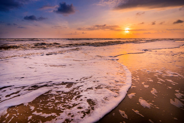 Bellissimo paesaggio nuvoloso sul mare con morbida onda di oceano blu sulla spiaggia sabbiosa durante l'alba. - Foto, immagini