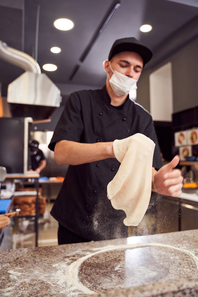 Pizzaiolo with prepearing dough for pizza - Photo, Image